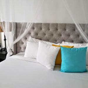 a bed with four pillows on top of it at KASA Roof Top 5 1 Bed 1 Bath Rooftop in San Juan