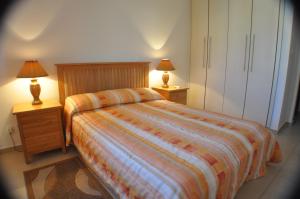 a bedroom with a bed and two night stands with lamps at 2 Bed, 2 Bath Apartment In Mandria in Mandria +16 photos