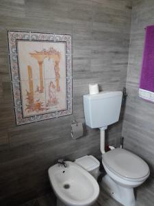 a bathroom with a white toilet and a purple towel at Vivenda Familia Pedro in Vila do Bispo