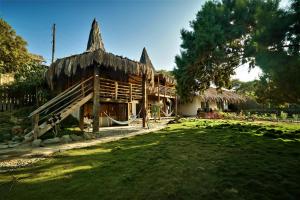 a large wooden house with a grass yard at PUERTO "TE" in Máncora