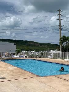 a person swimming in a swimming pool at Villa Marina Village Apartment in Fajardo