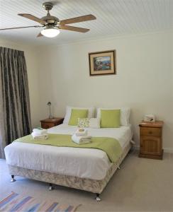 a bedroom with a bed with a ceiling fan at Broxholme B&B in Denmark