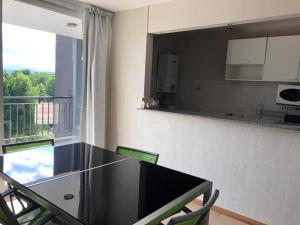 cocina con mesa negra, sillas y ventana en Condominio Monte Molinos, en Villa Ciudad de América