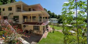 uma casa com um cão à frente dela em Charlotte Villa em Takamaka