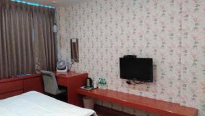a hotel room with a bed and a tv on the wall at 社長的家 in Luodong +49 photos