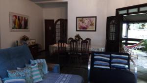 a living room with a table and a blue couch at Mansão Adonai nas Cachoeiras de Penedo in Penedo