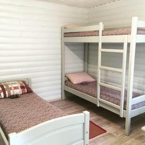 a bunk bed room with two bunk beds and a ladder at Guest House Muhtuya in Sarma