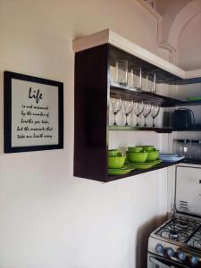 a kitchen with plates and glasses on a shelf at Sunny Palm Villas in Laborie
