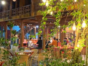 a group of people sitting at tables in a restaurant at Maison Teahouse homestay in Ha Giang