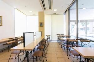 a classroom with tables and chairs and windows at Hotel Econo Yokkaichi in Yokkaichi