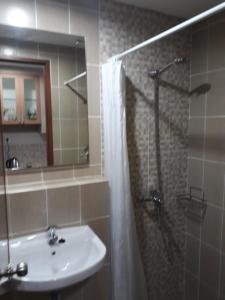 a bathroom with a sink and a shower with a mirror at ENVIRO Studio in Cikarang
