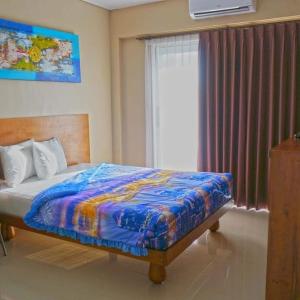 a bedroom with a bed and a large window at Brielle guest house in Jimbaran