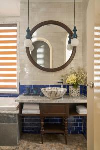 a bathroom with a sink and a mirror at Sofiana My Khe Hotel & Spa- Rooftop Pool Bar in Danang