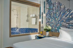 a bedroom with a bed and a bathroom with a shower at Sofiana My Khe Hotel & Spa- Rooftop Pool Bar in Danang