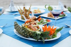 a table with plates of food and a glass of wine at Royal Lanta Resort & Spa in Ko Lanta