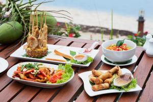 a wooden table with plates of food on it at Royal Lanta Resort & Spa in Ko Lanta