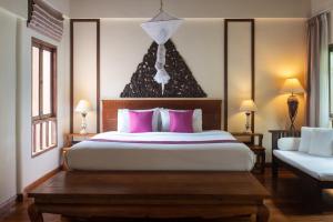 a bedroom with a large bed with pink pillows at Royal Lanta Resort & Spa in Ko Lanta
