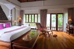 a bedroom with a large bed and a desk and chairs at Royal Lanta Resort & Spa in Ko Lanta