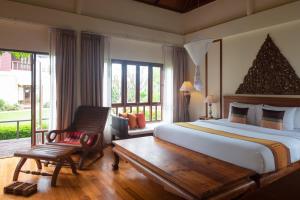 a bedroom with a large bed and a chair at Royal Lanta Resort & Spa in Ko Lanta