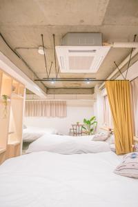a room with three beds and a ceiling with aperature at AMP FLAT Nishijin 2 in Fukuoka