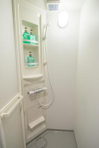 a white bathroom with a shower with a glass door at AMP FLAT Nishijin 2 in Fukuoka +19 photos