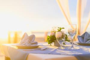 a table with a blue table cloth and two wine glasses at Royal Lanta Resort & Spa in Ko Lanta