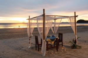 a table set up on the beach with a tent at Royal Lanta Resort & Spa in Ko Lanta