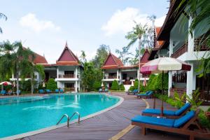a resort swimming pool with chairs and an umbrella at Royal Lanta Resort & Spa in Ko Lanta +37 photos