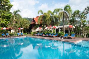 a pool at a resort with blue chairs and umbrellas at Royal Lanta Resort & Spa in Ko Lanta