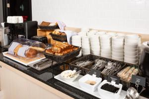 a breakfast buffet with bread and dishes on a counter at AZIMUT City Hotel Vladivostok in Vladivostok