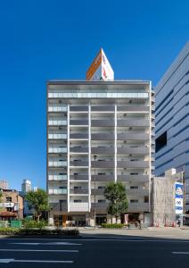 a tall white building with a sign on top of it at Meet Me Umeda Nishi in Osaka