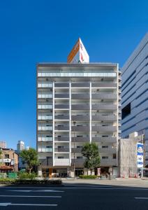 un edificio blanco alto con un cartel encima en Meet Me Umeda Nishi, en Osaka