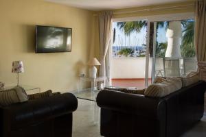 een woonkamer met 2 banken en een glazen tafel bij Magnificent Port-Beach 5* Luxury Residence in Benalmádena