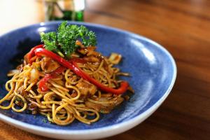 a blue plate of food with noodles on a table at Kama Hotel in Medan