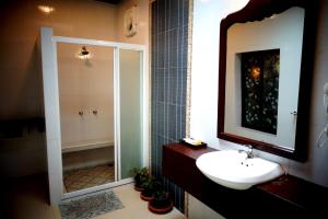 a bathroom with a sink and a shower and a mirror at Sala Done Khone Hotel in Ban Khon