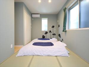 a bedroom with a large white bed with a window at COTO Tokyo Shibuya 7 in Tokyo