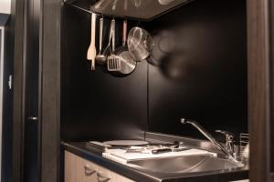 a kitchen with a sink and a black wall at EARTHMANS OSAKA-JO in Osaka