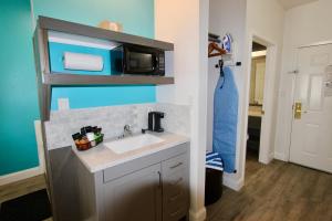 una pequeña cocina con fregadero y microondas en Hotel Pensacola en Pensacola