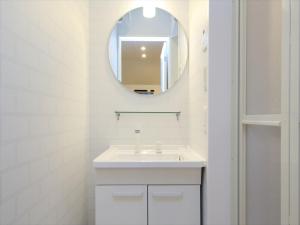 a white bathroom with a sink and a mirror at COTO Tokyo Shibuya 7 in Tokyo +24 photos