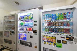 dos máquinas expendedoras blancas con refrescos y bebidas en Hotel Econo Kameyama, en Kameyama