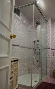 La salle de bains est pourvue d'une douche avec une porte en verre. dans l'établissement Magnificent Port-Beach 5* Luxury Residence, à Benalmádena