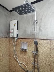 a shower in a public bathroom with a shower coil at Yotin Guest House in Trat +53 photos
