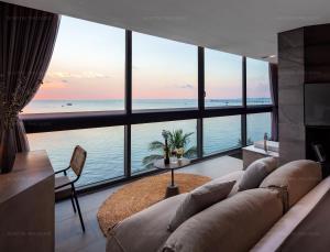 M Hotel Phu Quoc في فو كووك: غرفة معيشة مع أريكة وإطلالة على المحيط