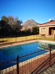 a swimming pool with a fence next to a house at The Graaff-Reinet Suites in Graaff-Reinet