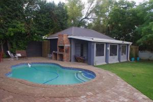 a small swimming pool in a yard with a shed at Relax in Joy & Mignon for a bushveld Feeling in Bloemfontein