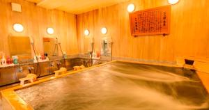 una gran piscina en una habitación de madera con lavabo en Nara Hakushikaso en Nara