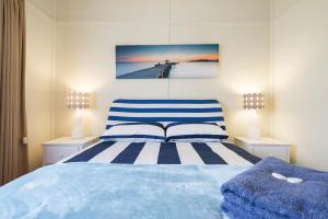 A bed or beds in a room at Nautique Beach House