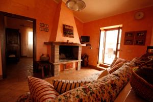 a living room with a couch and a fireplace at Relais La Cerreta in Capalbio