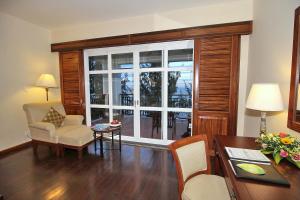 ein Wohnzimmer mit einem Tisch und Stühlen sowie einem großen Fenster in der Unterkunft Novela Muine Resort & Spa in Mui Ne