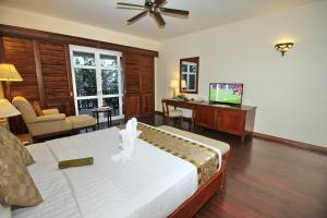 a bedroom with a bed and a living room with a desk at Novela Muine Resort & Spa in Mui Ne